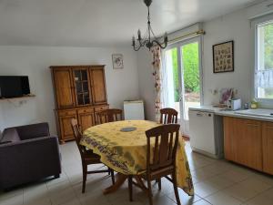 een keuken met een tafel met een gele tafelkleed erop bij Chez Jaja et Phiphi in Bourg-et-Comin