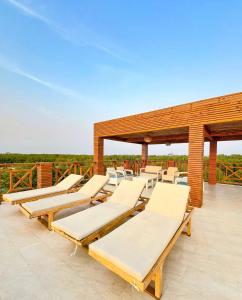 - une rangée de chaises longues sur la terrasse dans l'établissement APARTASUITE A UN PASO DEL MAR, à Tolú