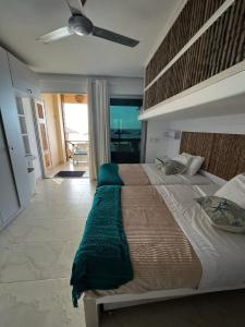 um quarto com uma cama grande e uma ventoinha de tecto em APARTASUITE A UN PASO DEL MAR em Tolú