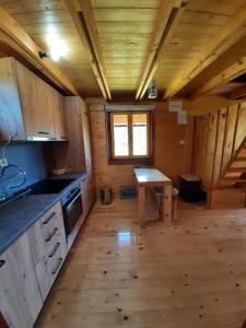 a kitchen in a log cabin with a table in it at Braća Kosorić in Han Pijesak
