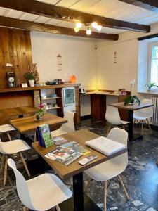 jadalnia z drewnianymi stołami i białymi krzesłami w obiekcie Zimmer Camere w mieście Sirolo