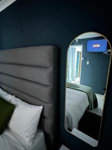 a mirror next to a bed in a room at The Legacy Airbnb in East London