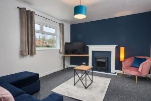 a living room with a couch and a chair and a tv at Contemporary 3-Bedroom Home in Hartlepool in Hartlepool