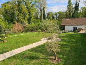 een tuin met een kleine boom in het gras bij Chez Jaja et Phiphi in Bourg-et-Comin