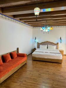 布哈拉的住宿－Istat Boutique Hotel，一间卧室配有两张床和吊灯。