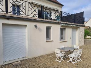 a patio with a table and chairs on a balcony at Chez Jaja et Phiphi in Bourg-et-Comin