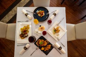 una mesa con platos de comida y bebidas. en Hotel Atlantis Medical, Wellness & Conference, en Hajdúszoboszló