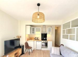 uma sala de estar com uma cozinha com um sofá e uma televisão em Charenton View Paris Door Best Location metro em Charenton-le-Pont