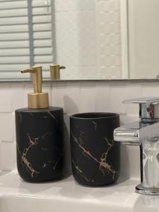 a bathroom sink with a black and gold soap dispenser at Chic Condo Karon Beach in Karon Beach