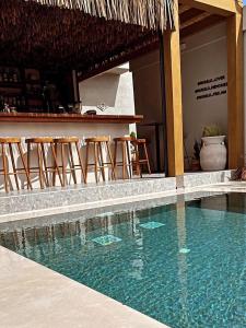 a swimming pool next to a bar with stools at Ikaros Suites in Amoudara Herakliou