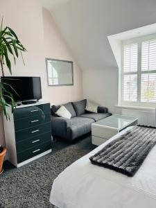 una sala de estar con una cama y un sofá en Penthouse Suite, Sea View, Close to Shops, Beach and Train, en St. Leonards