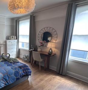 a bedroom with a desk and a bed and a mirror at Large Bedroom in beautiful house in London
