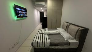 un sofá en una habitación con TV en la pared en Cozy Studio Kuala Lumpur by LH, en Kuala Lumpur