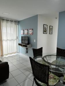 a living room with a glass table and chairs at Excelente apartamento Verano Ponta Negra 02 in Natal