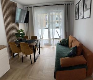 ein Wohnzimmer mit Sofa und Tisch in der Unterkunft Apartamenty Baltic Sea Navigator C1 in Kołobrzeg + 3 Fotos