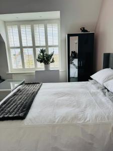a bedroom with a large white bed and a mirror at Penthouse Suite, Central St Leonards, Sea View in St. Leonards
