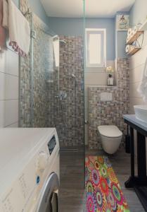 a bathroom with a shower and a toilet and a sink at Apartman More in Novigrad Dalmatia