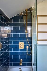 a blue tiled bathroom with a shower and a tub at Cosy retreat, perfectly located just a min walk from Deal Beach and Castle in Deal