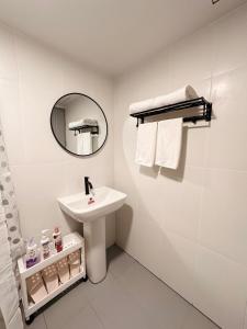 La salle de bains blanche est pourvue d'un lavabo et d'un miroir. dans l'établissement Mountain view & Quiet Cozy Condo, à Chiang Mai