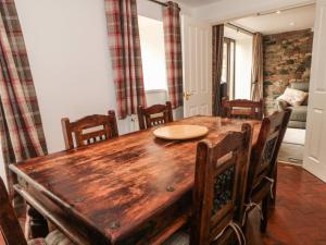 a dining room with a wooden table and chairs at Saddleback Barn in Penrith