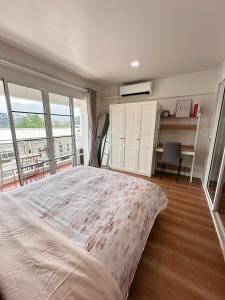 - une chambre avec un grand lit et un balcon dans l'établissement Mountain view & Quiet Cozy Condo, à Chiang Mai