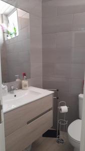 a bathroom with a sink and a toilet and a mirror at Cantinho do Céu in Alcácer do Sal
