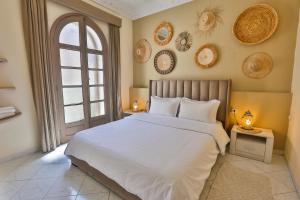 Un dormitorio con una gran cama blanca y una ventana en My Home in Essaouira en Esauira