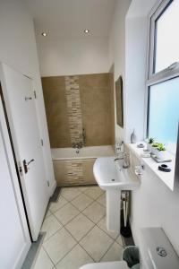 a white bathroom with a sink and a tub at Holiday Home Hot Tub & Sauna in Bournemouth