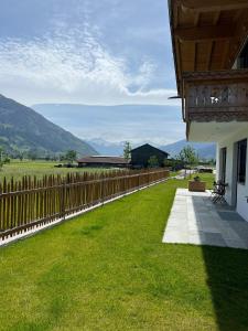 a fence in front of a house with a yard at Landhaus Huber in Fügen