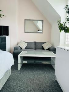 a living room with a couch and a mirror at Penthouse Suite, Central St Leonards, Sea View in St. Leonards