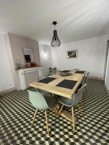 a dining room with a wooden table and chairs at Les Agapanthes in Vaux-en-Beaujolais