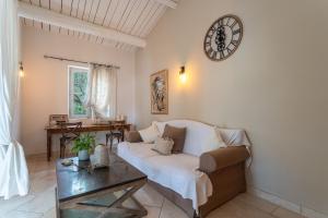 ein Wohnzimmer mit einem Sofa und einer Uhr an der Wand in der Unterkunft La Bastide de Basson - Luxe sur Correns in Correns