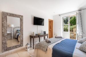ein Schlafzimmer mit einem blauen Bett und einem Spiegel in der Unterkunft La Bastide de Basson - Luxe sur Correns in Correns