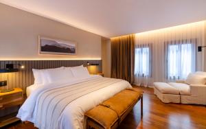 una habitación de hotel con una cama grande y una silla en El Bodeguero Hotel en Salta