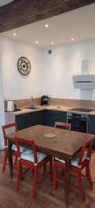 a kitchen with a table and chairs and a clock on the wall at Élégant 2 chambres, Les Dentellières de la Cathédrale in Troyes