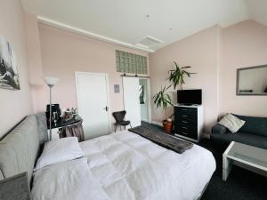 a bedroom with a white bed and a couch at Penthouse Suite, Central St Leonards, Sea View in St. Leonards