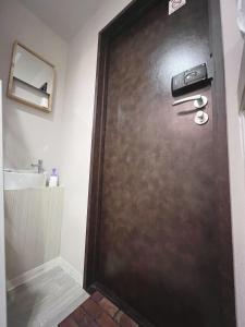 a brown door in a bathroom with a sink at 誠家　MAKOTO HOSTEL in Tokyo