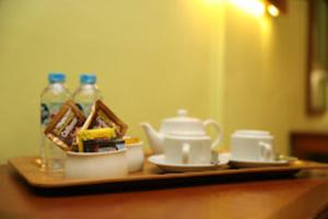 a tray with a tea pot and two bottles of water at Stay 'd Kuningan in Jakarta