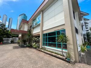 a building with palm trees in front of it at Stay 'd Kuningan in Jakarta