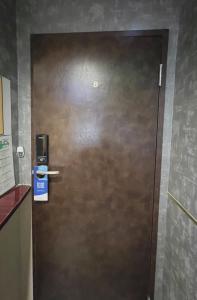 a metal door in a room with a sign on it at 誠家　MAKOTO HOSTEL in Tokyo