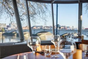 a table with wine glasses in a restaurant with a view of a bridge at Large Bedroom in beautiful house in London