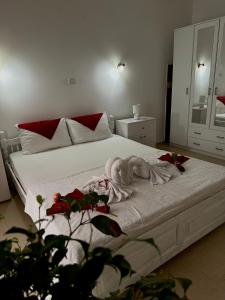 een slaapkamer met een wit bed met rode kussens bij Apartman Djordje in Budva