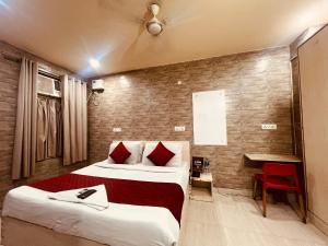 a hotel room with two beds and a red chair at Hotel Model Town Metro View in New Delhi