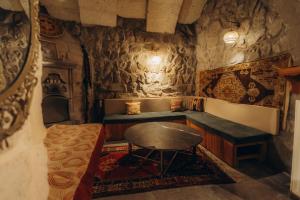 a room with a table and a bench in a room at Anatolia Raymonde Cave House in Uçhisar
