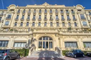 een groot gebouw met twee auto's geparkeerd voor het bij 4 stars Palais Hermitage, 5 pers, AC, Full confort in Nice