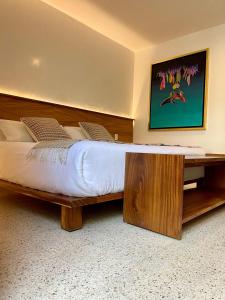 a large bed with a wooden frame in a room at Hotel Boutique Casa de Arte Oaxaca, Art Gallery & Pool in Oaxaca City