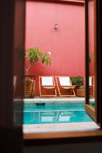 two chairs sitting next to a swimming pool at Hotel Boutique Casa de Arte Oaxaca, Art Gallery & Pool in Oaxaca City