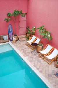a group of chairs sitting next to a swimming pool at Hotel Boutique Casa de Arte Oaxaca, Art Gallery & Pool in Oaxaca City