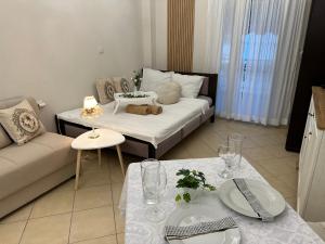a living room with a bed and two tables at Изглед море студио Алекс Неа ПЕРАМОС in Néa Péramos