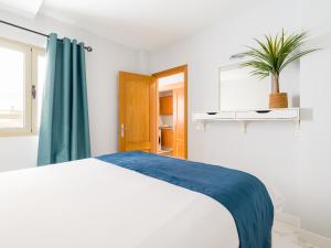 1 dormitorio con cama blanca y maceta en Avatar Auditorio, en Las Palmas de Gran Canaria